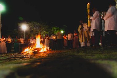Valenca, Bahia, Brezilya - 08 Nisan 2023: Katolikler mumlarını yakmak için Cumartesi gecesi kutsal şenlik ateşinin etrafındalar. Valenca, Bahia 'da kutsal bir hafta.