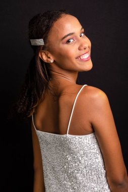 Genç bir kızın portresi, gülümseyen, güzel, beyaz elbiseler giyen. Siyah arkaplanda izole.