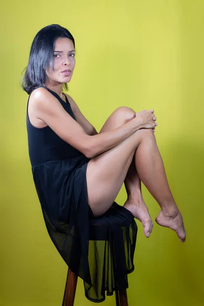 Krásná Modelka Dlouhých Černých Šatech Sedící Dřevěné Stoličce Nohama Nataženýma — Stock fotografie