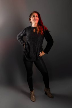 Stüdyodaki esmer kadın model, konsantre ve kendinden emin. Liderlik kavramı. Gri arkaplanda izole.