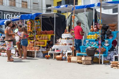 Nazare das Farinhas, Bahia, Brezilya - 08 Nisan 2023: Caxixis fuarı sırasında Nazare das Farinhas, Bahia 'da sergilenen sergilere bakan insanlar görülüyor.