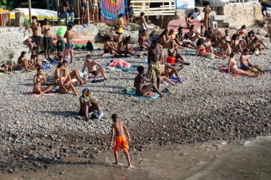 Salvador, Bahia, Brezilya - 14 Ocak 2022: İnsanlar Salvador, Bahia 'daki Gamboa bölgesinde kumsalda güneşlenirken görülüyor.
