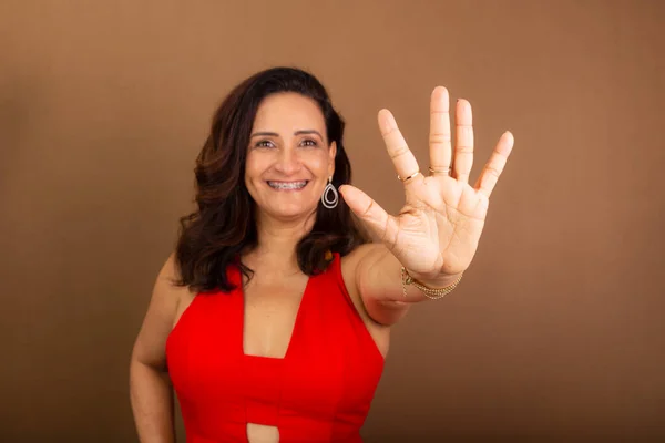 快乐的女人用手指做第五位的画像 激励人的人 在褐色背景下被隔离 — 图库照片