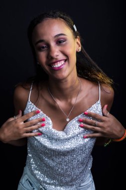 Siyah arka planda izole edilmiş beyaz elbiseli genç bir kızın stüdyo portresi..