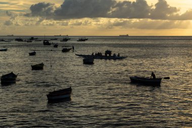 Salvador, Bahia, Brezilya - 14 Ocak 2022: Salvador, Bahia 'daki Modern Sanat Müzesi' nin plajında günbatımına karşı denizdeki teknelerin silueti.