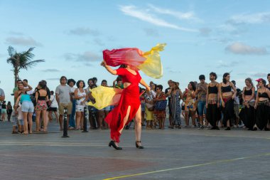 Salvador, Bahia, Brezilya - 22 Ekim 2022: Salvador, Bahia 'daki Farol da Barra' da bir sokak sanatçısının dans gösterisi sırasında insanlar görülüyor.