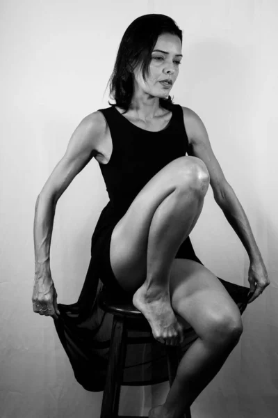 Černobílý Portrét Krásného Módního Modelu Sedícího Dřevěné Stoličce Držícího Oblečení — Stock fotografie