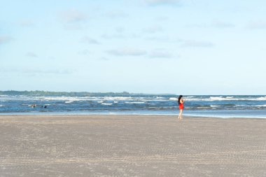 Valenca, Bahia, Brezilya - 13 Ocak 2023: Öğleden sonra Valenca, Bahia 'da Guaibim plajında denizin tadını çıkaran bir turist.