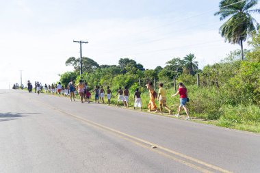 Santo Amaro, Bahia, Brezilya - 24 Temmuz 2022: İnsanlar Santo Amaro, Bahia 'daki Acupe ilçesinde yolda yürürken görülüyor.
