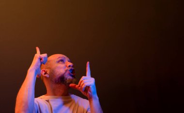 Komik el hareketleri yapan mutlu kel adam. Güç, başarı ve başarı kavramı. Koyu kırmızı arkaplanda izole.