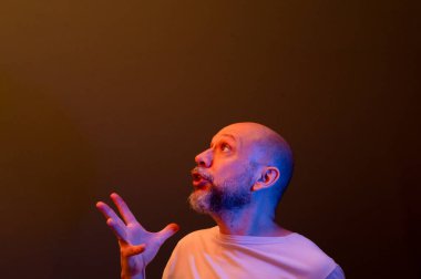 Komik el hareketleri yapan mutlu kel adam. Güç, başarı ve başarı kavramı. Koyu kırmızı arkaplanda izole.