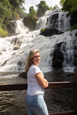 İskelede büyük bir şelaleye bakan bir kadın. Büyük yumruk. Çevre. Brezilya 'nın Itubera kenti.