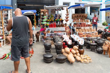 Nazare das Farinhas, Bahia, Brezilya - 08 Nisan 2023: İnsanlar Nazare das Farinhas, Bahia sokaklarındaki Caxixis fuarı sırasında seramiklerden yapılan resimlere bakarken görülüyor.
