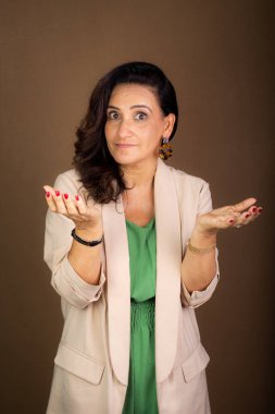 Gülümseyen portre ve kendine güvenen koçluk yapan kadın el hareketi yapıyor. Motivasyon ve demokratik yönetim. Kahverengi arkaplanda izole.