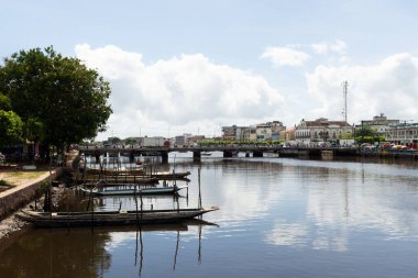 Valenca, Bahia, Brezilya - 10 Ocak 2023: Bitkiler, ağaçlar ve ticari binalarla çevrili Una Nehri manzarası. Brezilya 'nın Bahia eyaletindeki Valenca turistik kenti. gezinilebilir nehir.