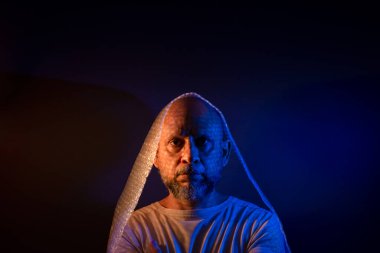 Kel, sakallı, kafasının etrafına baloncuk sarılı bir adam. Koyu kırmızı arkaplanda izole.