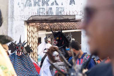 Santo Amaro, Bahia, Brezilya - 23 Temmuz 2023: Canavarlar gibi giyinmiş insanlarla birlikte kültür grubu Caretas de Acupe, Santo Amaro, Bahia sokaklarında bir sunum sırasında görüldü.