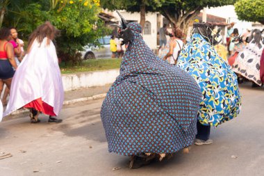 Santo Amaro, Bahia, Brezilya - 23 Temmuz 2023: Kültür grubu Caretas de Acupe, ilçenin sokaklarında kostüm içinde gösteri yapıyor. Santo Amaro, Bahia.