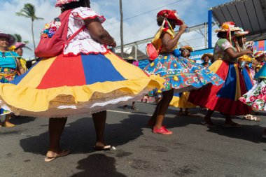 Salvador, Bahia, Brezilya - 11 Şubat 2023: Fuzue, Bahia, Brezilya 'daki karnaval öncesi Fuzue sırasında eteklerini kıvırarak karakter yürüyüşü yapan kadınlar.