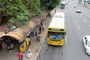 Salvador, Bahia, Brezilya - 11 Ağustos 2023: İnsanlar, Bahia 'nın Salvador kentindeki bir ticaret merkezi olan Avenida Tancredo Neves' deki otobüs durağında durdukları görüldü..