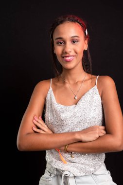 Genç kız portresi, gülümsüyor, kameraya bakıyor. Siyah arkaplanda izole.