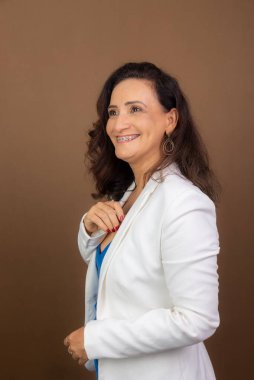 Yukarı bakan kadın koçun portresi. Müşteriyi cesaretlendirmek ve motive etmek için kendinden emin. Kahverengi arkaplanda izole.