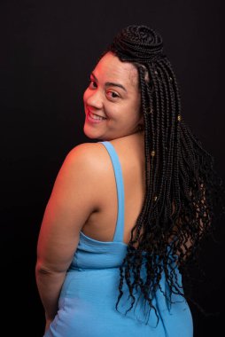 Stüdyoda siyah arka planda mavi kıyafetli güzel bir kadının fotoğrafı. Pozitif kişi.