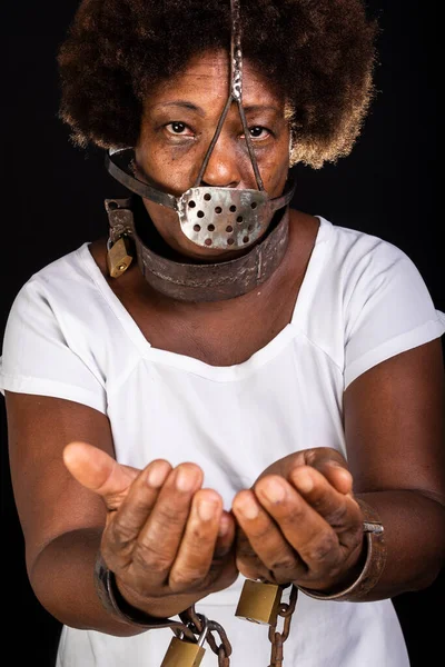 Portrait of a black woman in chains with an iron mask on her face, representing the slave Anastacia. Slavery in Brazil.