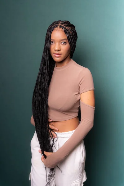 Stock image Portrait of young, beautiful black model with long braided hair. Isolated on dark cyan background.