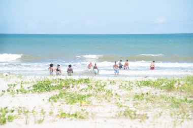 Valenca, Bahia, Brezilya - 27 Aralık 2022: İnsanlar Bahia 'nın Valenca kentindeki Guaibim plajında banyo yapıyor ve yürüyor.