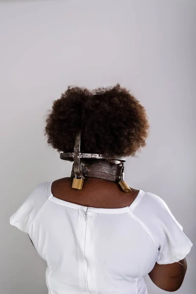Portrait of a black woman in chains, from the back. Slave Anastacia. Slavery in Brazil.