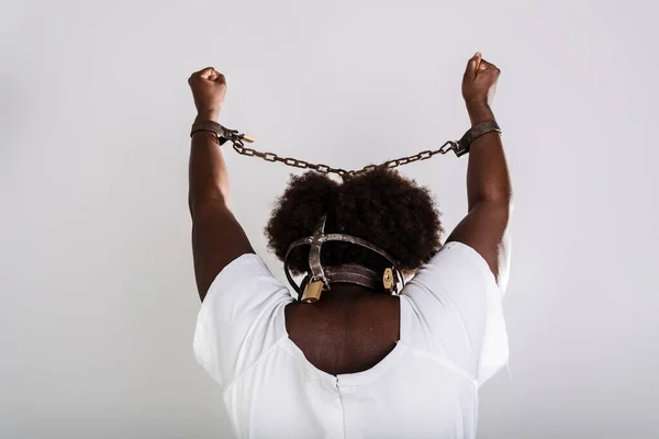 Portrait of a black woman in chains, from the back. Slave Anastacia. Slavery in Brazil.