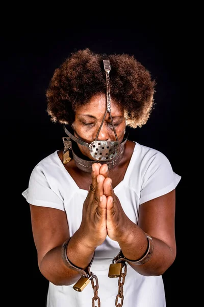 Black woman in chains with an iron mask on her face, representing the slave Anastacia. Slavery in Brazil.