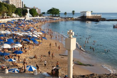 Salvador, Bahia, Brezilya - 25 Ağustos 2023: İnsanlar Salvador, Bahia 'daki Porto da Barra plajında güneşlenirken ve plaj futbolu oynarken eğleniyorlar.