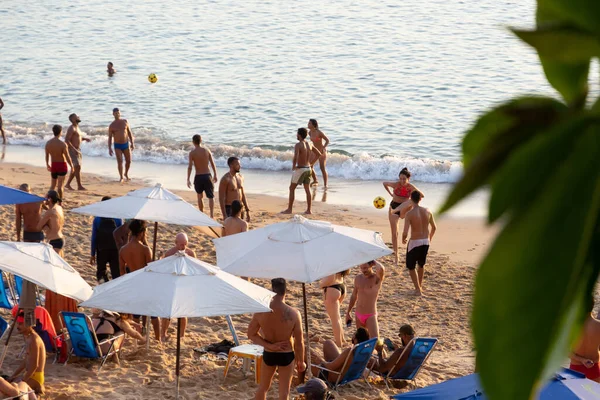 Salvador, Bahia, Brezilya - 25 Ağustos 2023: İnsanlar Salvador, Bahia 'daki Porto da Barra plajında güneşlenirken ve plaj futbolu oynarken eğleniyorlar.