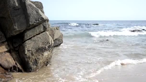 海の波は晴れた日にビーチの黒い岩に衝突する リラックス感 — ストック動画