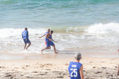 Salvador, Bahia, Brezilya - 20 Şubat 2022: İnsanlar Salvador, Bahia 'daki Farol da Barra plajında plaj futbolu oynarken eğleniyorlar.