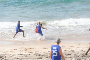 Salvador, Bahia, Brezilya - 20 Şubat 2022: İnsanlar Salvador, Bahia 'daki Farol da Barra plajında plaj futbolu oynarken eğleniyorlar.