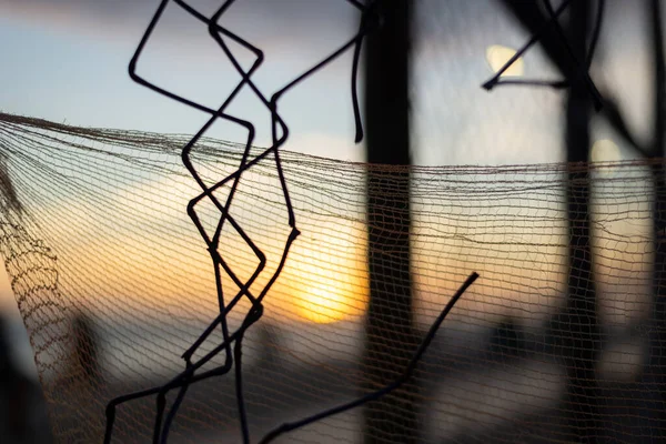 夕阳西下在海滩边 人和物被尼龙网勾勒出来 摘要摄影概念 — 图库照片