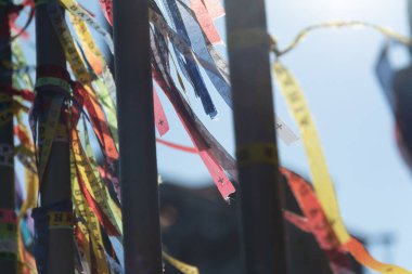 Salvador, Bahia, Brezilya - 2 Eylül 2023: Salvador, Bahia 'da bulunan Pelourinho' da bulunan Largo Terreiro de Jesus çeşmesinin demiryollarına bağlı hatıra kurdelelerinin yakın çekimi.