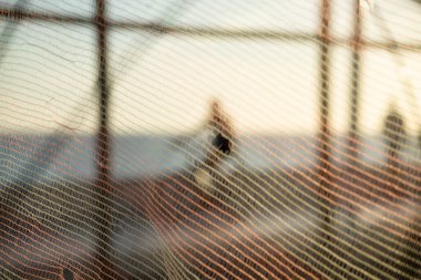 Bisikletçilerin silueti ve gün batımına karşı sahilde yürüyen insanlar. Fiziksel egzersizler ve zihnin rahatlaması..