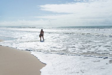 Kuzeydoğu Brezilya 'da tropik bir plajın kumlarında yürüyen beyaz bir kadın. Tatildeki kişi