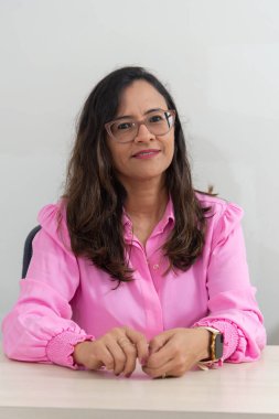 Ofisinde bir psiko-pedagog oturuyor, hastayı bekliyor, poz veriyor ve kameraya bakıyor. Okul gösterisi. Akıl sağlığına dikkat et..