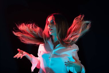 Güzel, genç, çekici, beyaz elbiseli, saçları öne doğru savrulan beyaz bir kadın. Siyah arkaplanda izole.