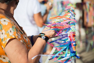 Salvador, Bahia, Brezilya - 7 Ocak 2022: Katolikler, Salvaldor, Bahia 'daki açık bir ayin sırasında Senhor do Bonfim kilisesinin korkuluklarına kurdele bağlarken görüldü..