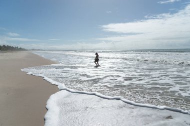 Kuzeydoğu Brezilya 'da tropik bir plajın kumlarında yürüyen beyaz bir kadın. Tatildeki kişi