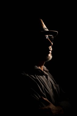 Karanlıktaki şapkalı dedektif portresi. Karanlık oda sanatı.