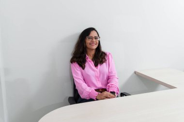 Ofisinde pembe giysiler içinde oturan bir psiko-pedagogun portresi. Okul performansına yardımcı oluyor. Akıl sağlığına dikkat et..