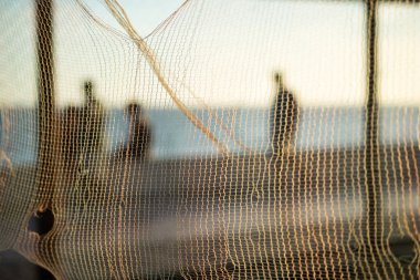 Siluet ve yaya figürleri öğleden sonra bir plajın kenarında yürüyorlar. Soyut fotoğrafçılık kavramı.