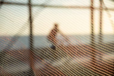 Bisikletçilerin silueti ve gün batımına karşı sahilde yürüyen insanlar. Fiziksel egzersizler ve zihnin rahatlaması..